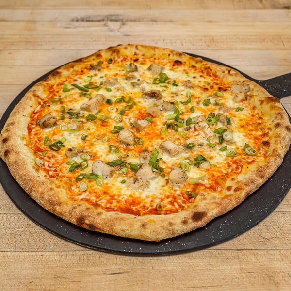 Roundabout Pizza's chicken pizza, topped with melted cheese, chicken pieces, and fresh green onions.